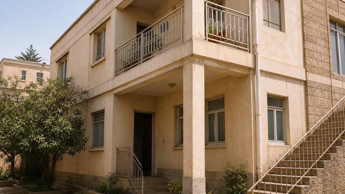 A sunlit Eritrean apartment home with balconies and a leafy courtyard